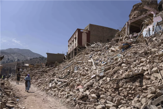 People walk amid the wreckage in the town of Imi N’tala. (Mosa’ab Elshamy / Associated Press)