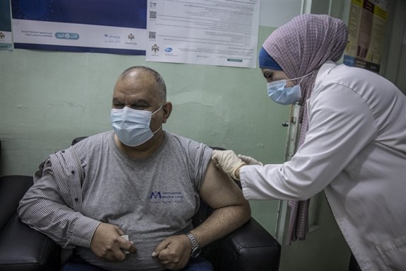 A medical worker administers a dose of COVID-19 vaccine at the Irbid Vaccination Clinic in Jordan via UNHCR by Jose Cendon