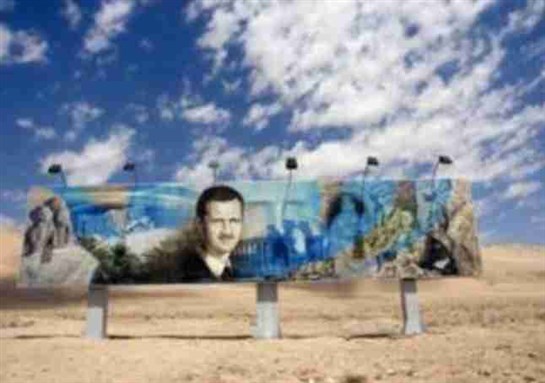 Billboard on road between Aleppo and Damascus showing Bashar al-Asad. Image from Wikipedia]