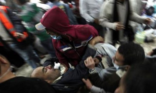 [Protesters rushing towards the field hospital in Tahrir square carrying a wounded man after military police attack on them. Image from Reuters]