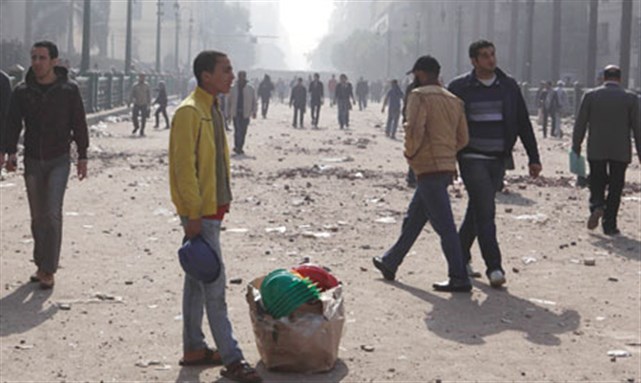 [A street vendor sells safety helmets in Tahrir Square in Cairo. Image from Reuters]