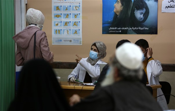 An employee of the United Nations Relief and Works Agency for Palestine Refugees (UNRWA) gives a shot of the Sputnik V Covid-19 vaccine for medical staff and the elderly, in the Gaza Strip (3 March 2021). Photo by Abed Rahim Khatib via Shutterstock.