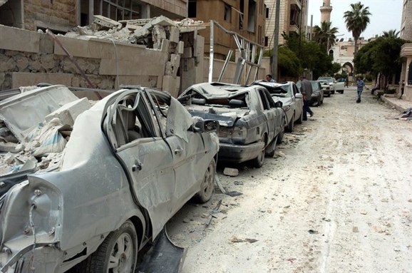 [A handout photo made available by by the official SANA, shows shattered cars at the site hit by two suicide bombings in Idlib, Syria, 30 April.(EPA)]