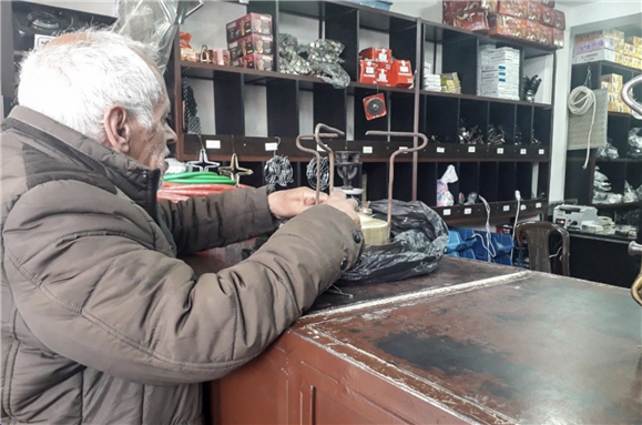 Abu Mohamed, a Syrian in Homs, returns to the store to fix his recently-purchased kerosene-lit stove which broke down from heavy usage. Abu Mohamed had joined the ranks of many others who returned to kerosene-lit appliances amidst nationwide fuel shortage and electricity outages.[Areeg Ali/Al Jazeera]