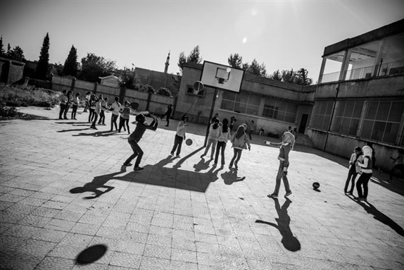 [A normal scene in a schoolyard in al-Malikiyah (Derek in Kurdish), al-Hasaka Governorate, Syria, where life goes on as usual since there has been little fighting in this region of Syria. Photo by Andy Spyra.]