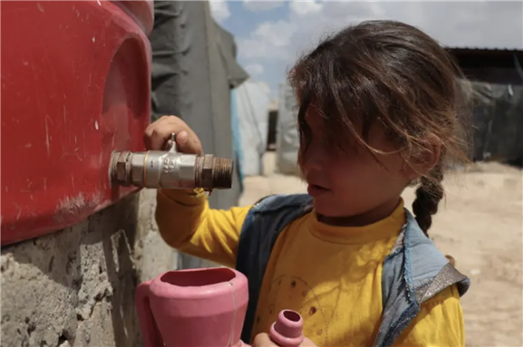 A girl fetches water from the tank in Al Hol camp, northeast Syria [Save the Children]