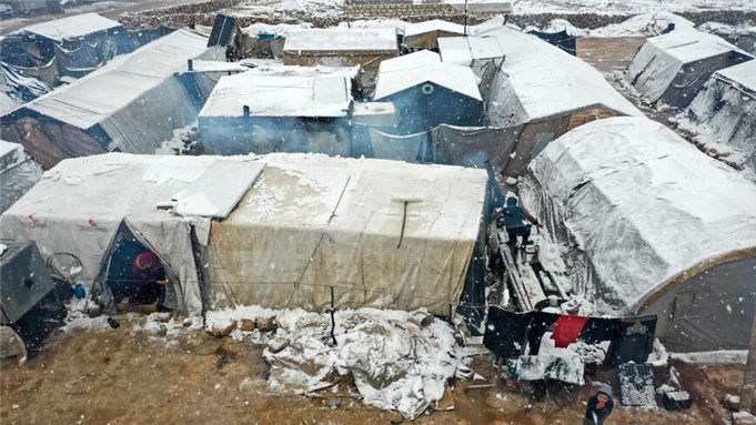 This aerial view shows tents covered in snow at a camp for internally displaced Syrians, near the town of Kafr Lusin, as a snow storm hit the region, at the border with Turkey in the rebel-held northwestern province of Idlib, Syria, March 13, 2022. - Omar Haj Kadour/AFP via Getty Images