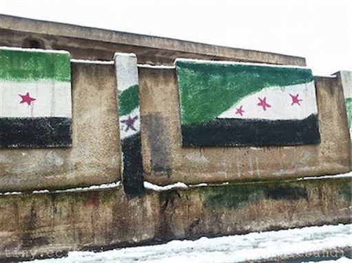 [Syrian opposition flags painted on the walls of a government school in Homs. Image by FreedomHouse via Flickr]
