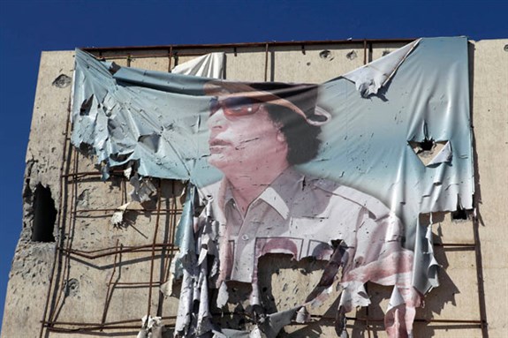 [A torn banner showing Muammar Gaddafi in Sirte. Photo by Asmaa Waguih]