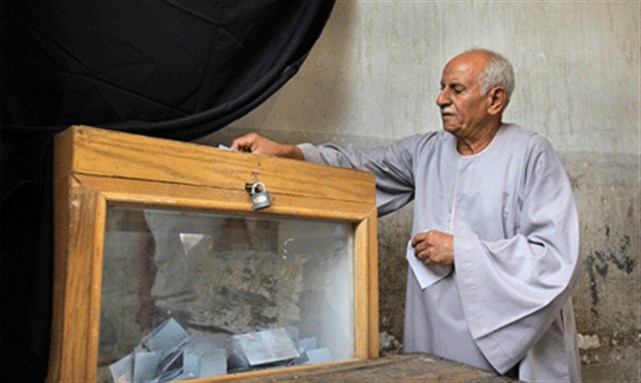 [An Egyptian man casts his vote in the parliamentary elections at a polling station in the Shubra neighborhood of Cairo. Image from AP.]