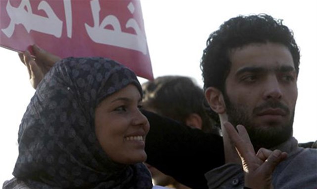 [Samira Ibrahim (L) flashes a victory sign as she attends a protest against military council violations and virginity tests against females at Tahrir Square in Cairo, 27 December, 2011. Image from Reuters]