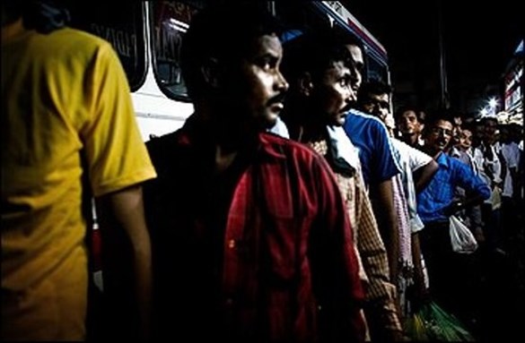 [Migrant workers in Dubai waiting for buses to their labor camp. Image from impactlab.net]