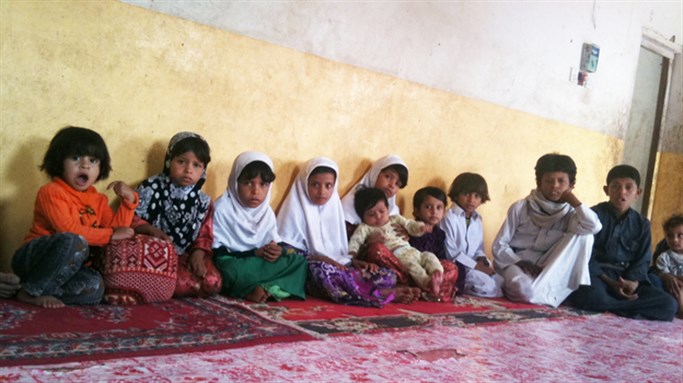 [Some of the 26 children of Saleh Qaid Toayman, who was killed with one of his sons in an airstrike on Oct. 14, 2011. The family says the eldest son, Azzedine, has joined an al-Qaida-affiliated group to avenge the father`s death. The group`s black banner hangs in the family`s home. The family says the militant group gives them a monthly stipend. Image by Kelly McEvers/NPR.]